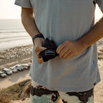 Man at beach, pulling pocket blanket out of pouch