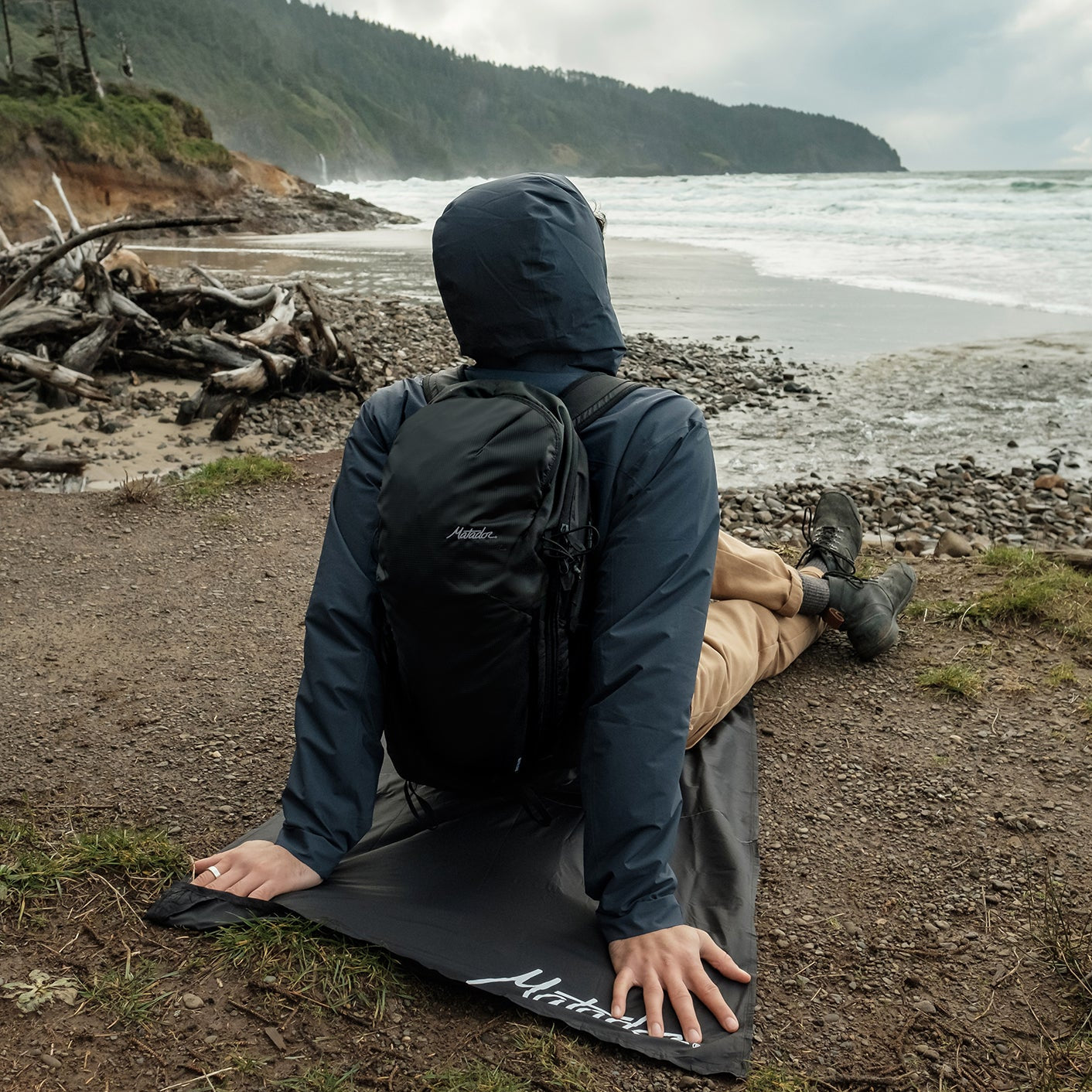 Man looking out at beach, sitting on pocket blanket