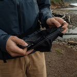 Man on beach unfolding pocket blanket