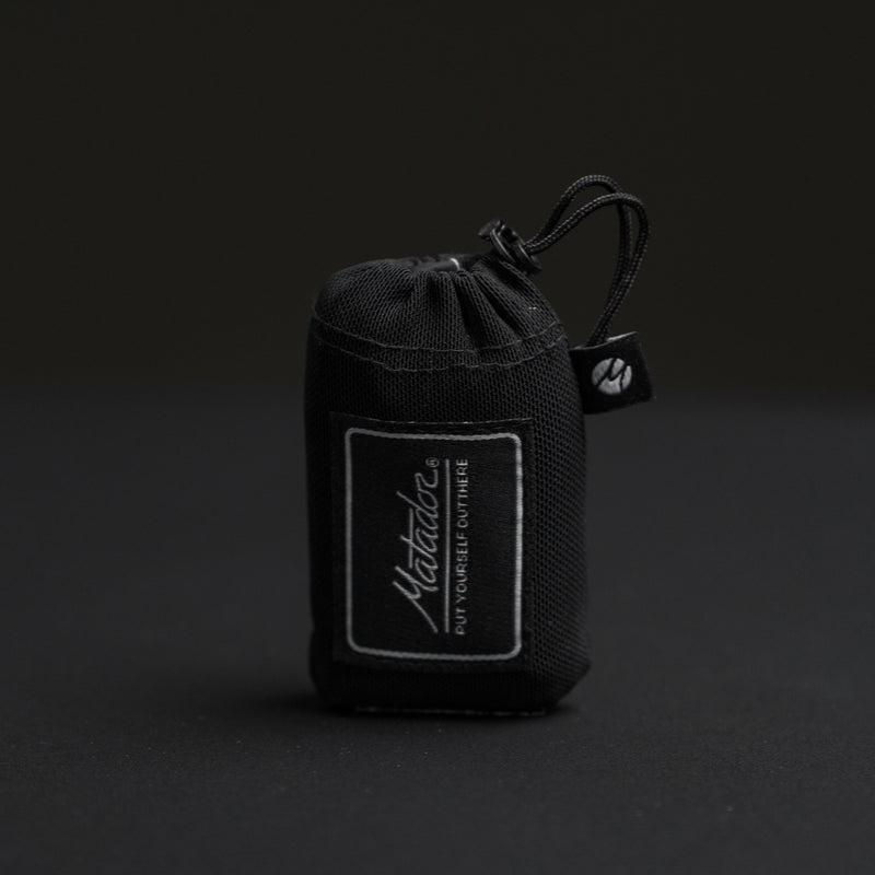 Packed down pocket blanket on black background