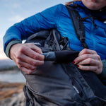 Woman taking trek towel out of pouch on backpack