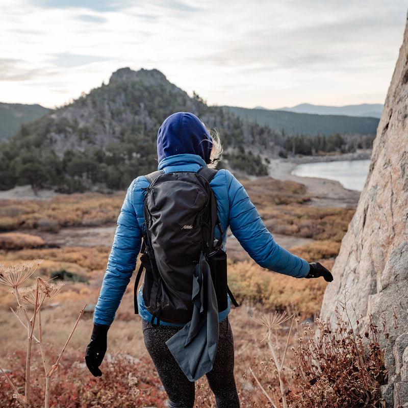 Woman hiking with trek towel hanging off her backpack