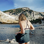 Woman at alpine lake with towel wrapped around her