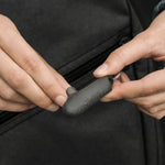 Hands placing earplugs into black case